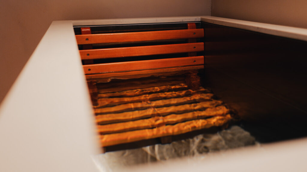 Bain japonais avec siège en bois partiellement immergé dans l'eau transparente